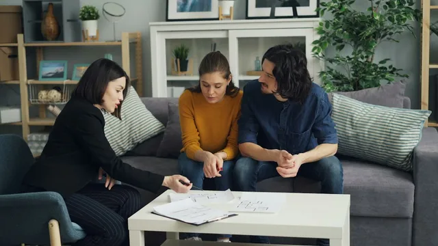 A family sitting with a provider on a couch, going through papers together