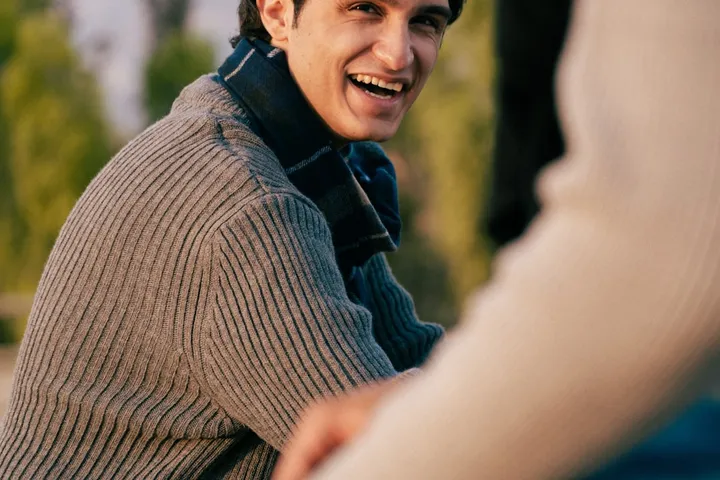 A man smiling warmly outdoors