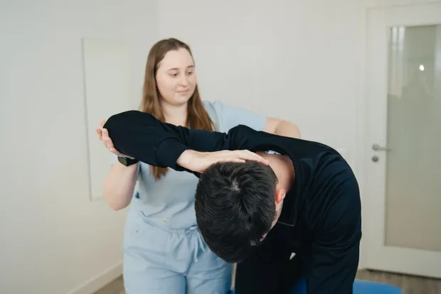 A woman guiding a man through a gentle stretch